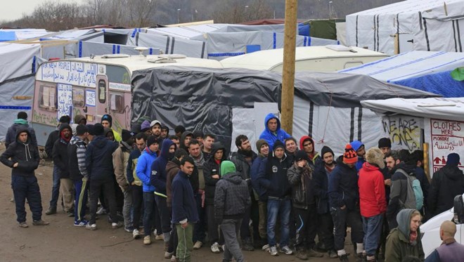 Migrants queue for clothes distribution in southern part of the camp known as the "Jungle", a squalid sprawling camp in Calais, northern France, February 26, 2016.